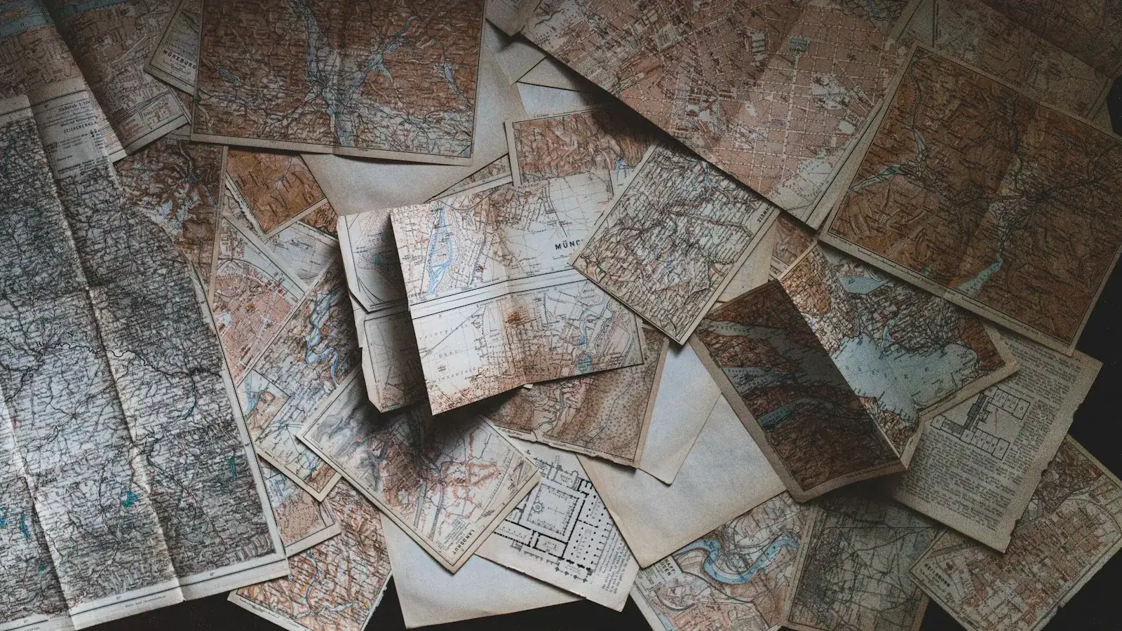 A scattered collection of old maps on a table