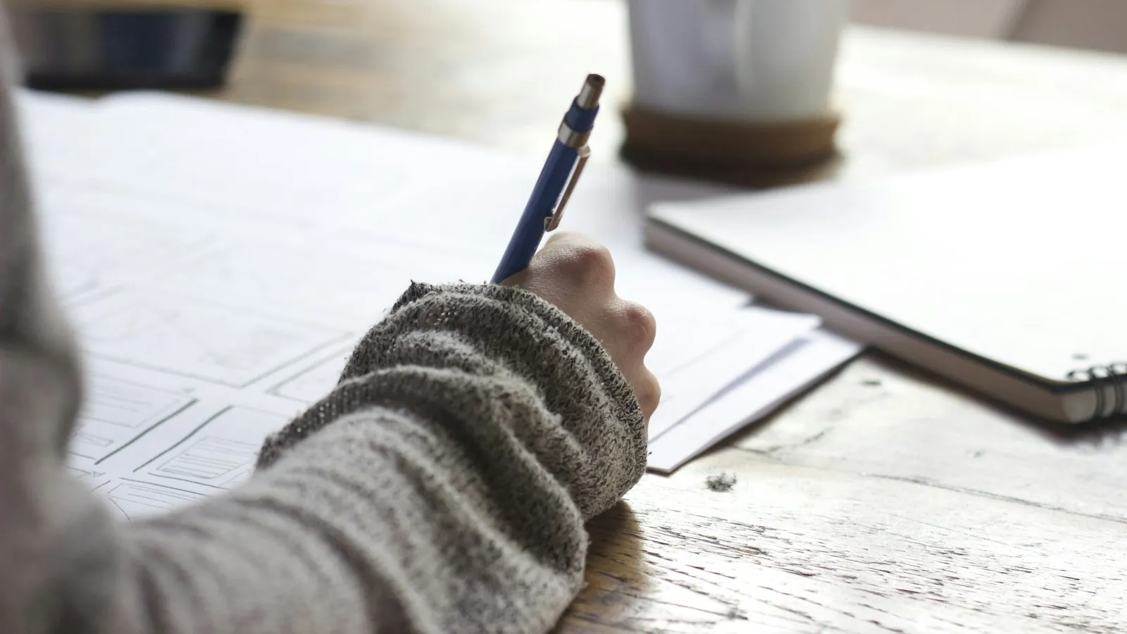 Person writing notes on paper at a desk