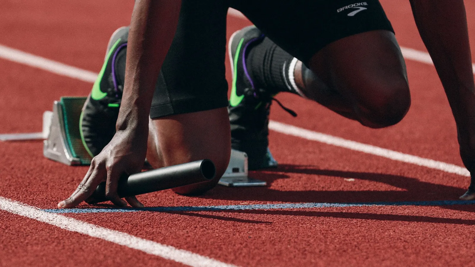 Sprinter crouched at the start line on a running track