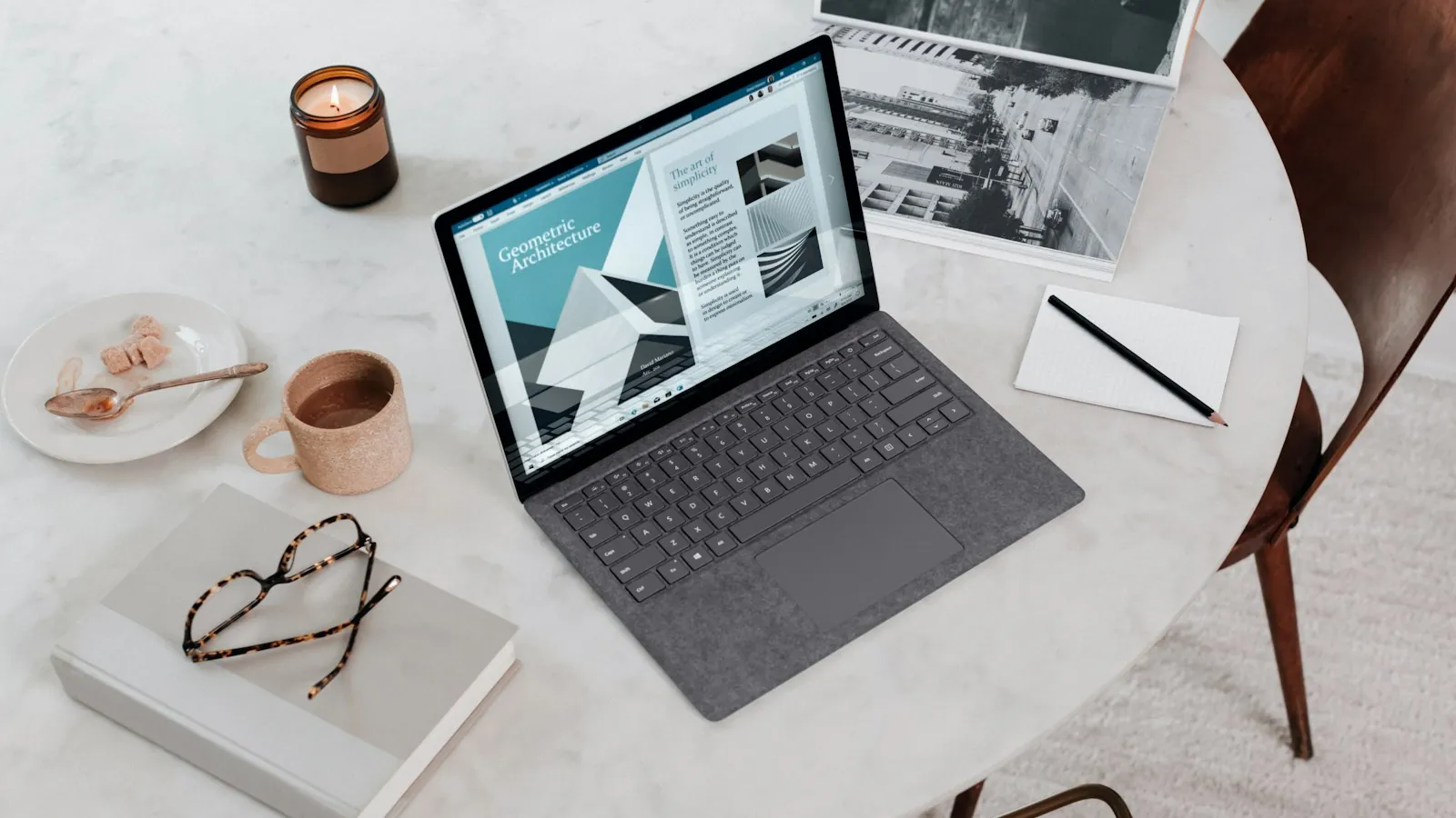 Laptop on a table beside a pair of glasses